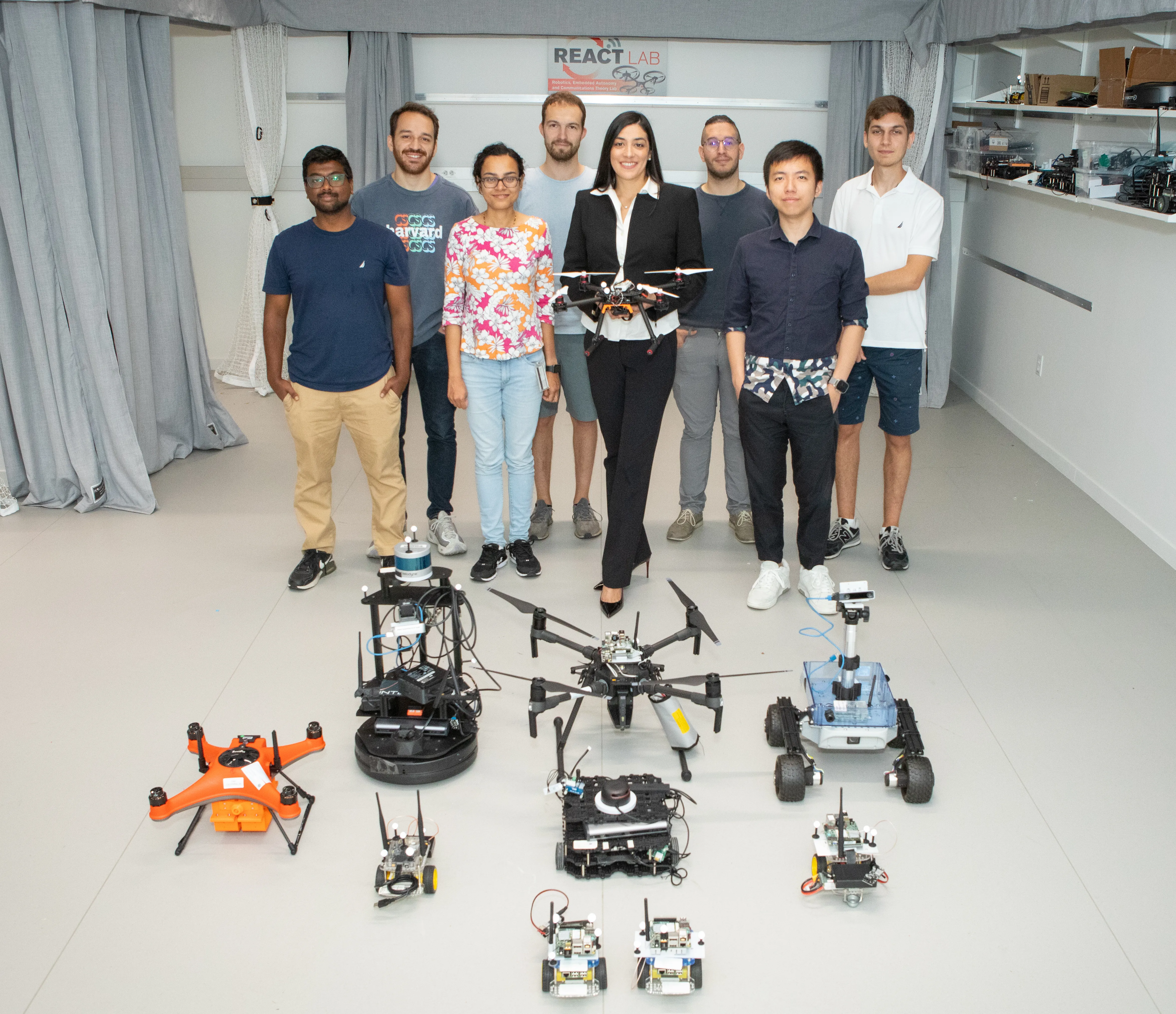 The REACT Lab team in the lab with our air and ground robot platforms